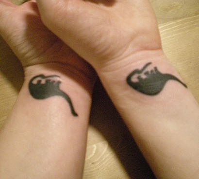 Matching dinosaur friendship tattoo on wrist