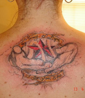 el tatuaje conmemorativo de una estrella roja en las manos hecho en color en la esplada