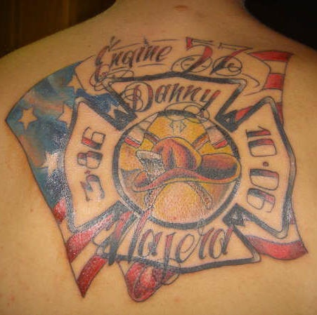 el tatuaje conmemorativo con la bandera americana, una chapa de bombero con fechas de la vida y el nombre