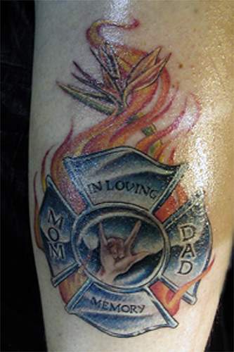 el tatuaje conmemorativo de la chapa de bombero en llamas de fuego en memoria de mama y papa
