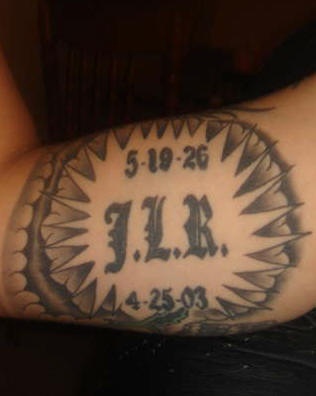 el tatuaje conmemorativo con iniciales en un circulo de traceria en color negro