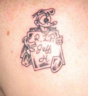el tatuaje conmemorativo rip " descansa en paz" de donald duck con un letrero