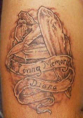 el tatuaje conmemorativo con una lapida, el nombre y la frase " a la memoria de .."