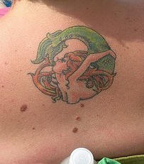 Tatuaggio delicato sulla spalla la sirena con la coda verde