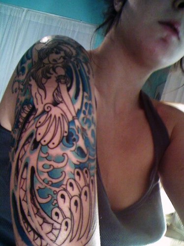 Tatuaggio colorato sul braccio la sirena & le onde