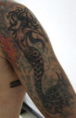 Elegant black mermaid tattoo on arm