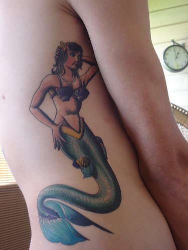 Detailliertes Tattoo von Meerjungfrau an der Seite
