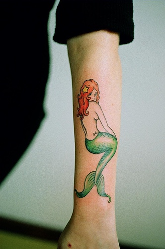 Tatuaggio colorato sul braccio la sirena con i capelli rossi