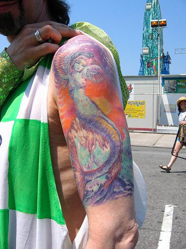 Buntes surrealistisches Tattoo mit Meerjungfrau