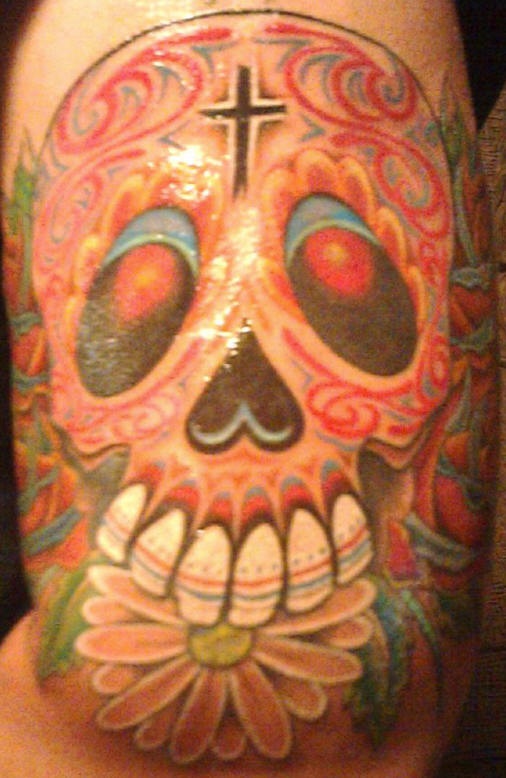 el tatuaje de una calavera mexicana colorada con la cruz en su frente