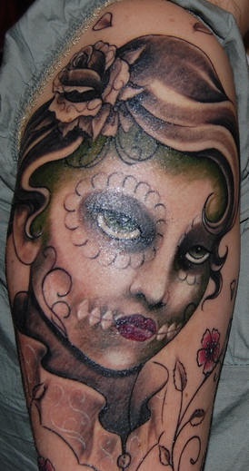 el tatuaje de una mujer maquillada para el &quotdia de muertos&quoten el brazo
