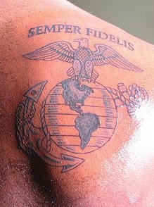 el tatuaje del simbolo militar de USMC en la espalda