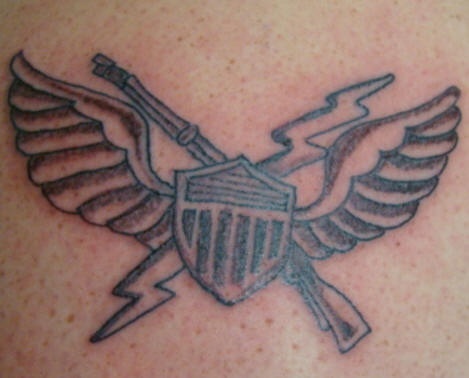 el tatuaje de un simbolo militar con alas ,un rayo y una escopeta