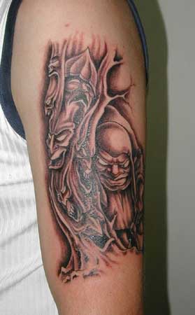 el tatuaje de un arbol con caras malvadas en el brazo