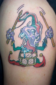 El tatuaje de un enano feo con un tambor hecho en color