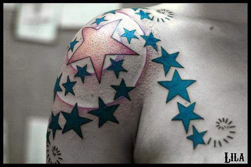 Tracería con estrellas en tinta azul tatuaje en el hombro