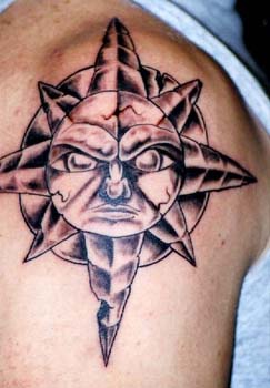 Símbolo del sol en piedra tatuaje en el hombro