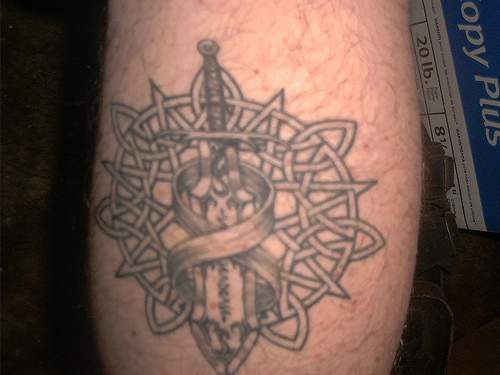 Celtic knot tracery with sword tattoo