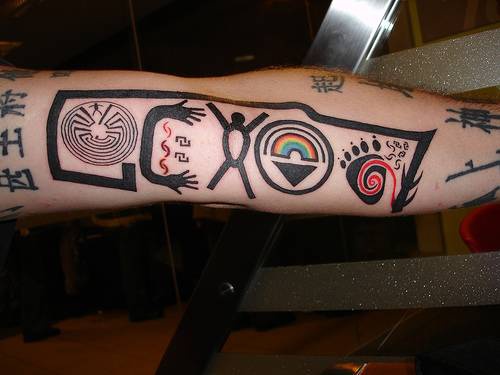 el tatuaje hecho parcialmente en color con simbolos de indios