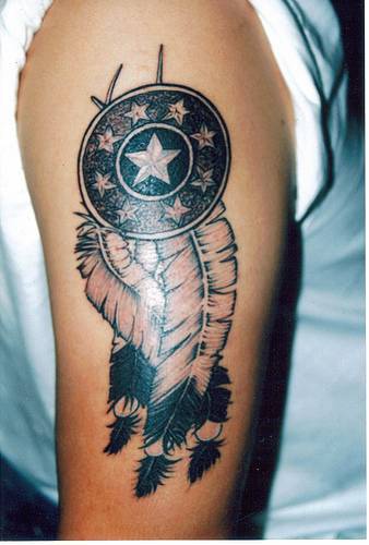 el tatuaje de un simbolo con estrellas y plumas indias hecho en tinta negra en el hombro