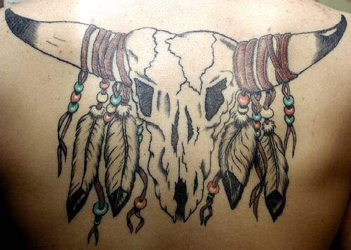 el tatuaje de una calavera de vaca con plumas indias