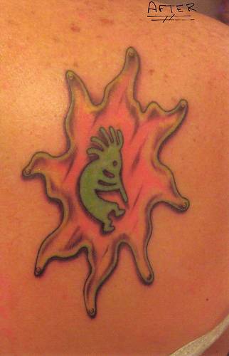 el tatuaje de un pequeño bailador tribal en el sol hecho en color rosa y verde