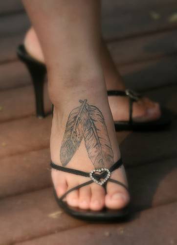 el tatuaje de pie con dos plumas indias