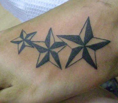 el tatuaje de pie con tres estrellas nauticas de color negro con blanco