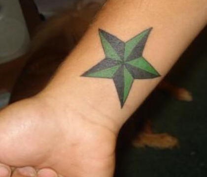 el tatuaje sencillo clasico de la estrella nautica en color verde con negro en la muñeca