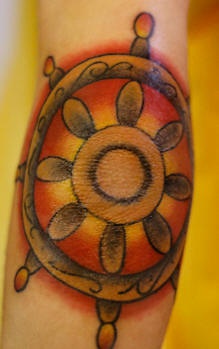 Colourful steering wheel of fortune tattoo