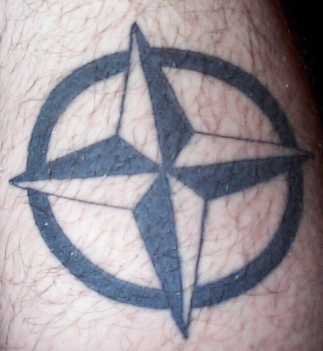 el tatuaje de una estrella nautica con cuatro puntas en un circulo