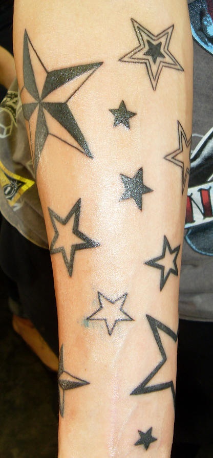el tatuaje de muchas estrellas hecho con tinta negra en el brazo