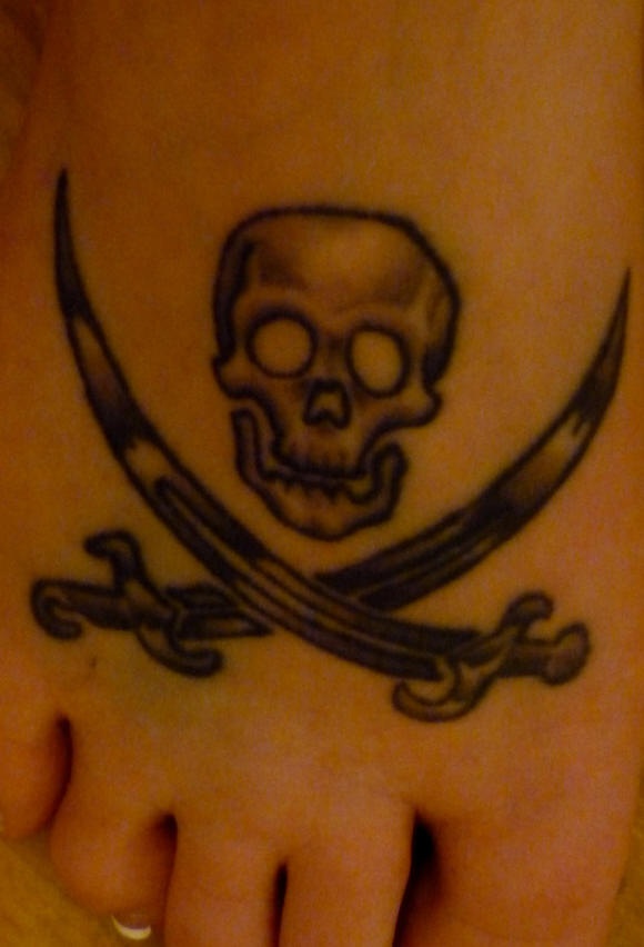 Skull and crossed swords tattoo