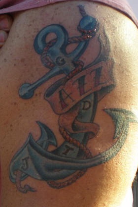 el tatuaje de una ancla azul con iniciales