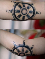 Steering wheel tattoo on elbow