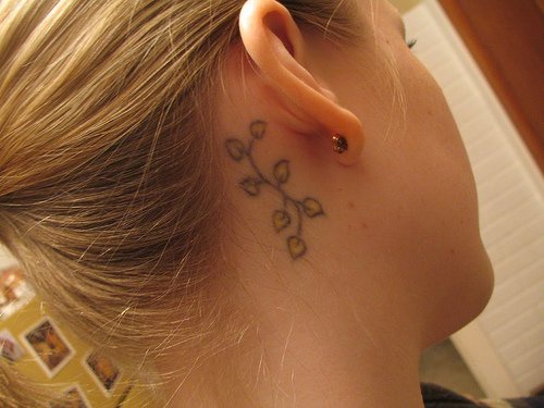 el tatuaje de una traceria floral hecho detras de la oreja