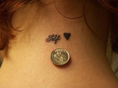 el tatuaje super pequeño de un nombre junto con un corazon en tinta negra
