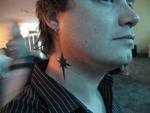 el tatuaje de una estrella sencilla de color negro hecho en el cuello