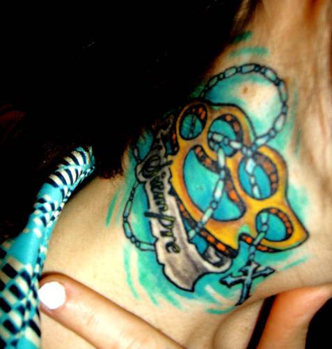 el tatuaje de un duster de oro con un rosario en el fondo azul