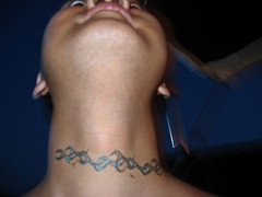 Flower tracery tattoo on front neck