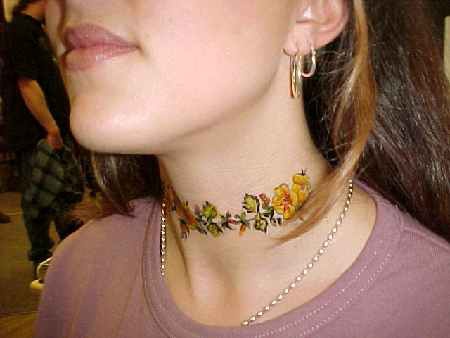 el tatuaje femenino de una traceria floral colorada hecho en el cuello