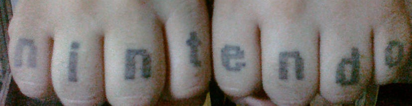 Tattoo mit einfacher Inschrift &quotNintendo" in Schwarz an Fingerknöcheln