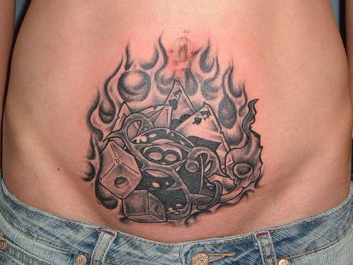Lower belly black tattoo with fire, magic 8 ball, bone and cards