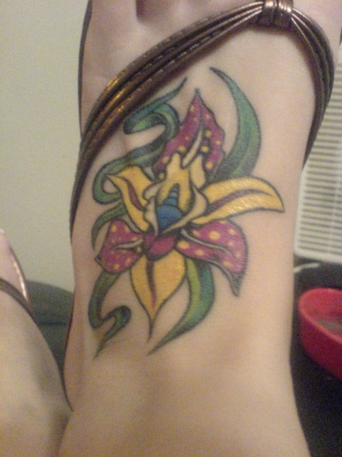 el tatuaje de una orquidea colorada hecho en el pie