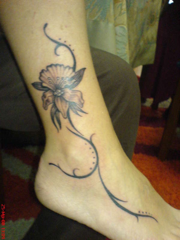 tatuaje de una orquidea negra elegante hecho en el pie