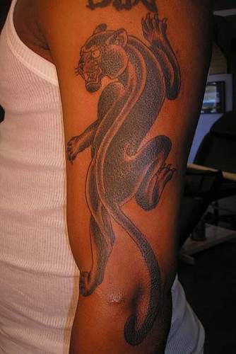 el tatuaje de una pantera negra hecho en el brazo