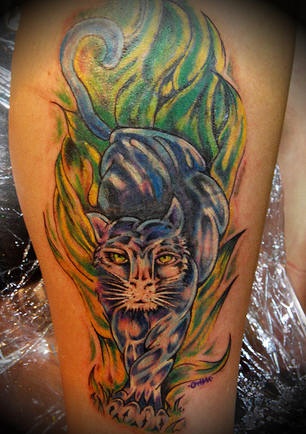 el tatuaje de una pantera cazando en el campo