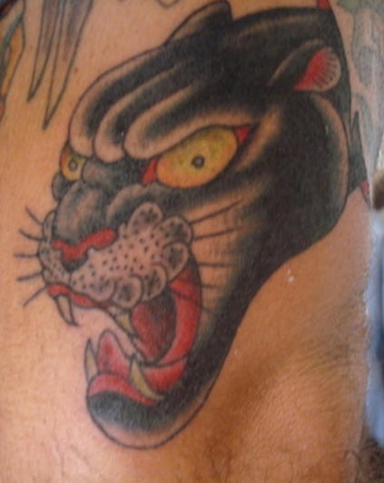 el tatuaje de una pantera  rugiendo hecho a color