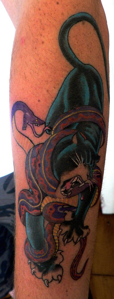 el tatuaje de una pantera peleando con una serpiente
