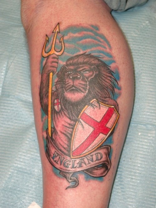 el tatuaje patriota de un leon humanizado con el escudo de inglaterra hecho en la pierna